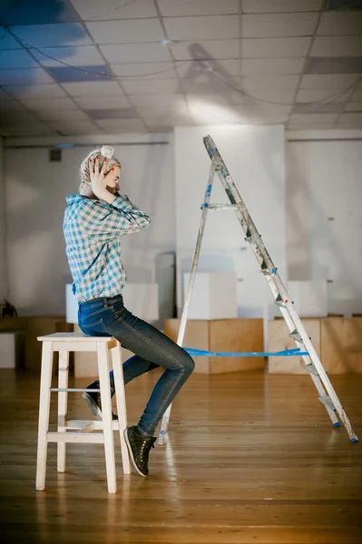 Girl and construction ladder. studio shot of a young woman with a construction ladder in the room