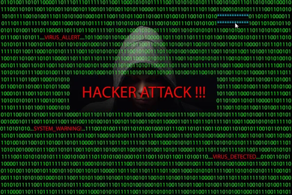 Hacker over a screen with binary code and warning messages