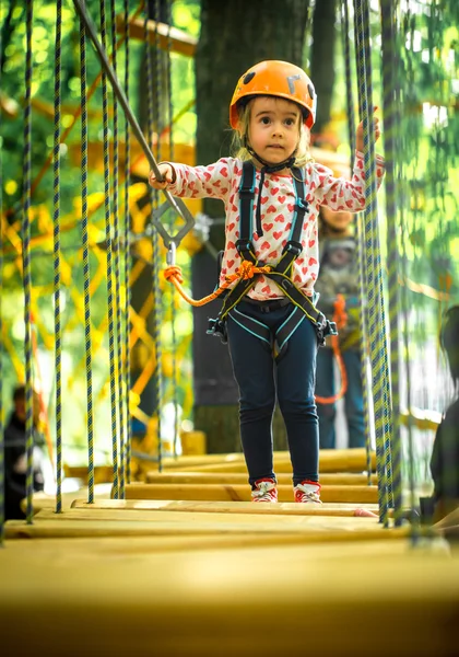 Sports happy kid climbs through the ropes