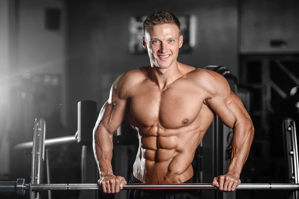 Strong athletic man fitness model showing six pack abs