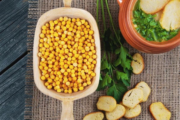 Pea soup in a pot with parsley and croutons, dried peas