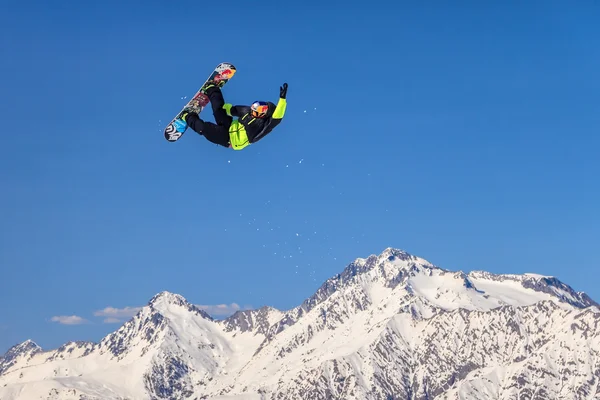 Snowboard rider flying from a ski jump