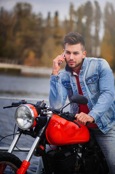 Trendy guy on a motorcycle talking on the phone
