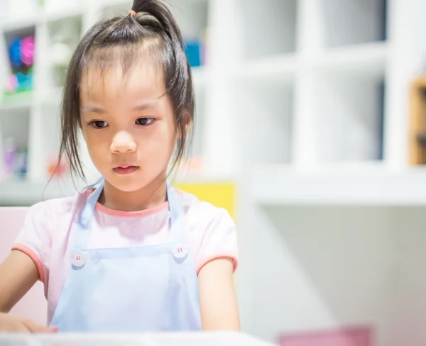 Cute Japanese baby girl in kitchen apron