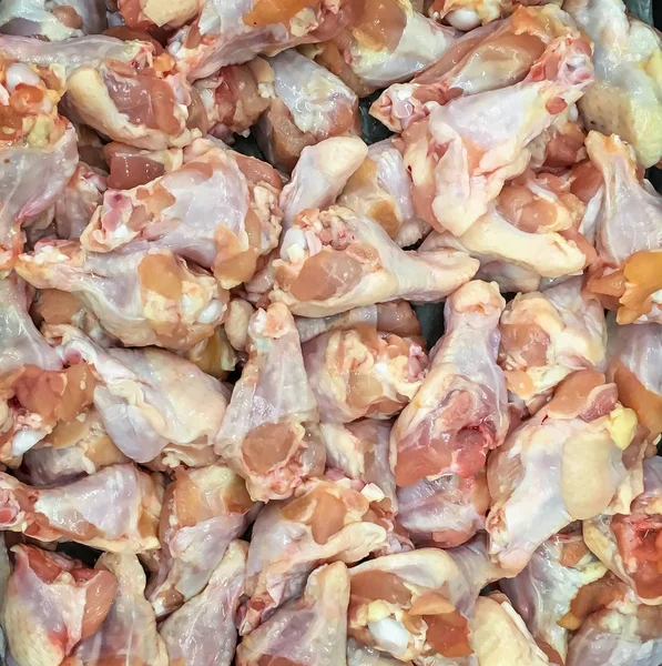 Fresh raw chicken on sale in retail display. Lot of raw chicken legs are put on ice to keep it freshness. Raw chicken meat are freeze for customer choice in supermarket.