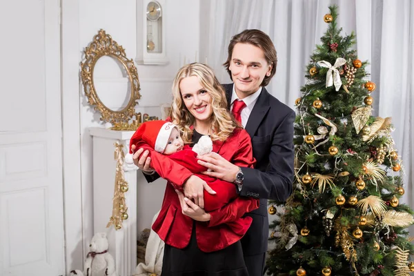 Christmas family in a christmas decorated room with a christmas tree and a fireplace