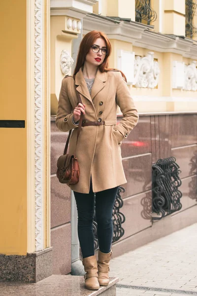 Business woman go to work in a beautiful coat with a bag