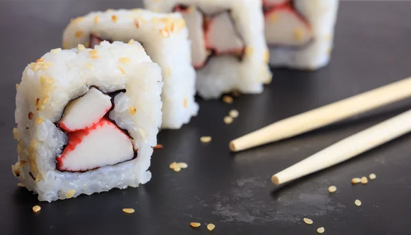 Sushi rolls on a black surface