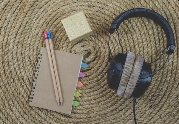 Notebook and headphone music  on a jute rope background
