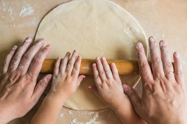 Children and dad hands rolled dough