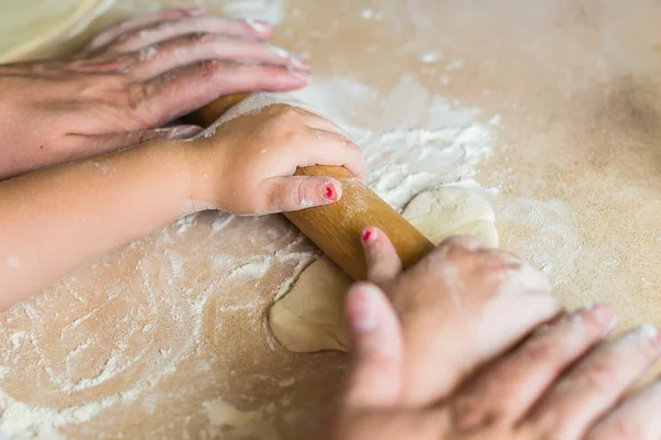 Children and dad hands rolled dough