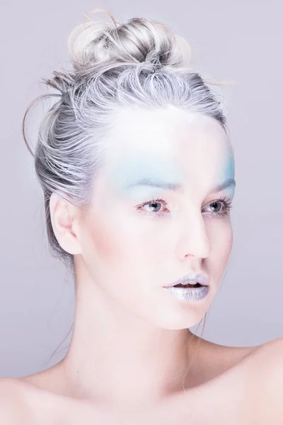 Model in creative image with silver blue artistic make-up