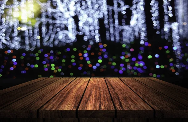 Wooden table in front of abstract blurred background of party night