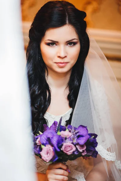 Portrait of beautiful bride with fashion veil posing at wedding morning. Makeup. Brunette girl with long wavy hair styling. Wedding dress.