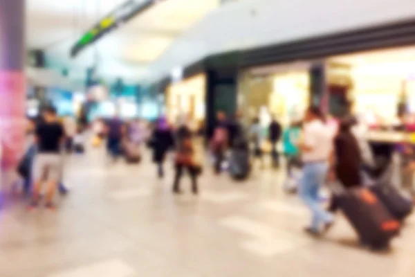 Blurred people in the shopping mall airport with wheel luggage