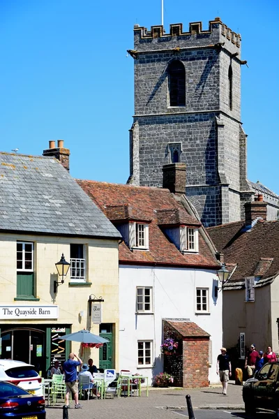 Lady St Mary parish church tower seen above shop buildings, Wareham.