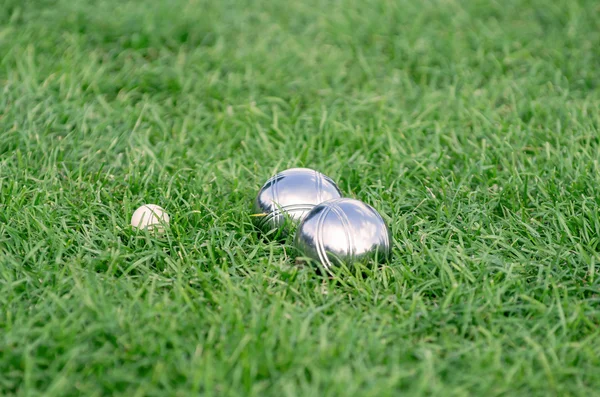 Close up of steel or metal boule balls on the green lawn