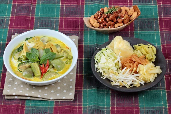 Green fermented flour curry  with mixed vegetables and spicy fried textured soy protein curry served with side disk as bean sprouts,cabbage,sweet radish and pickle