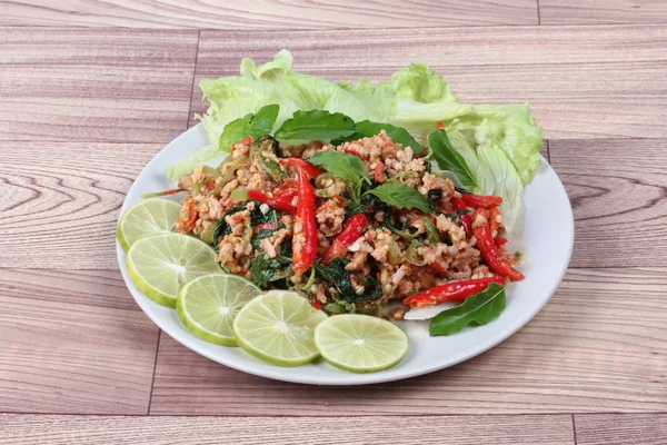 Fried spicy basil with minced pork topped sliced green lemon and and lettuce is top ten of popular Thai food.