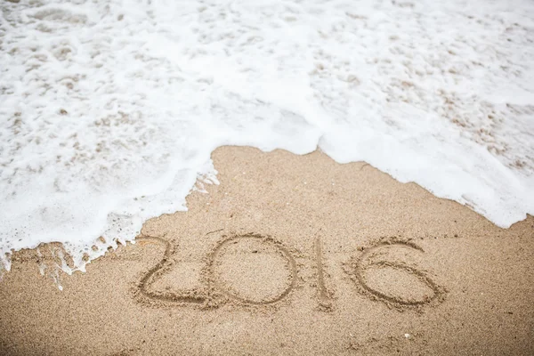 Good bye 2016 hand writing in sand beach
