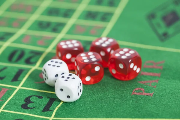Roll of the red and white dice on  game table in  casino