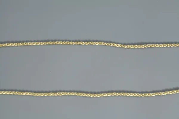 Golden rope isolated on gray background