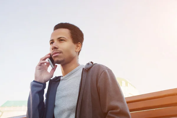 Young man in sport wear talking on mobile phone. Guy outdoors