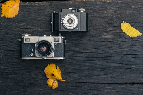 Old film camera on grunge dark wooden background