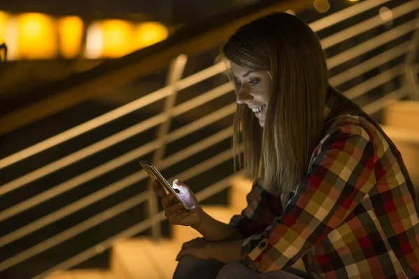 Woman read on text message on phone at night