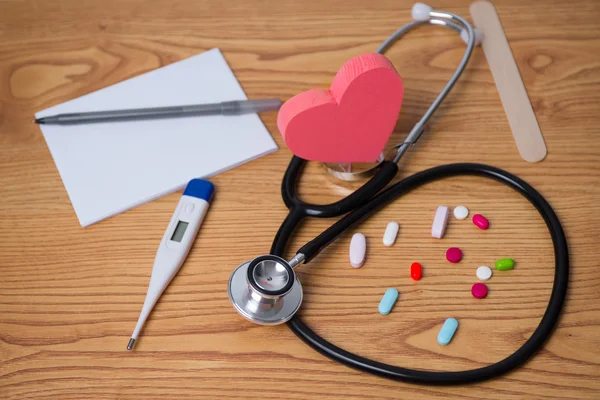 Stethoscope and tablets, heart in the middle, prescription, tablet pen, and thermometer photo for heart disease. Dr  appointment