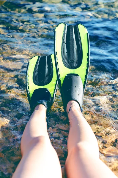 Snorkeler relaxing on a beach. Have a rest. Fins. Beach vacation snorkel. Relaxing on summer holidays lying down in water after snorkelling