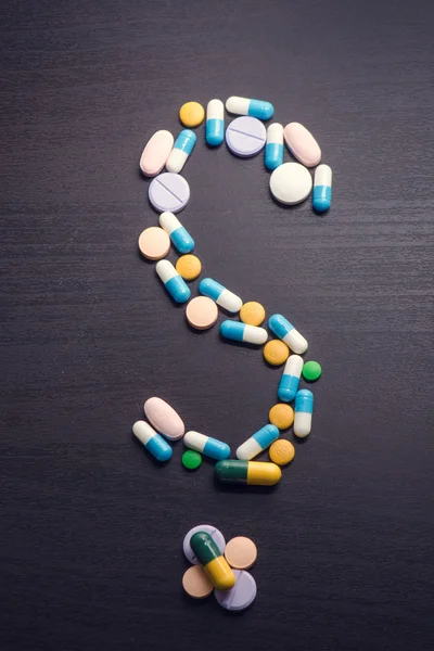 Pharmacy background on a black table.Question. question mark. Tablets on a black background. Pills. Medicine and healthy. Close up of capsules. Differend kind of pills