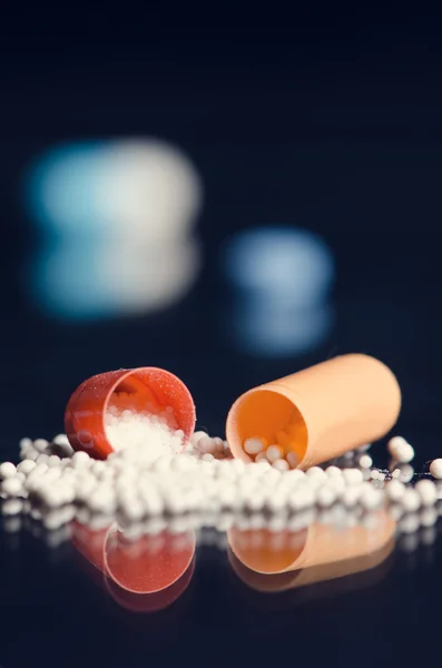 Scattered capsule. Pharmacy background on a black table. Tablets on a black background. Pills. Medicine and Health. Close up of capsules. Differend kind of pills