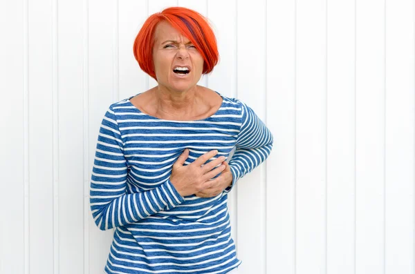 Middle-aged redhead woman suffering a heart attack