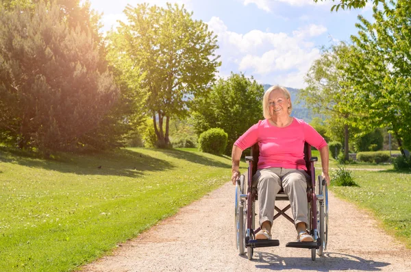 Elderly woman smiles while seated in wheel chair