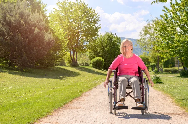 Elderly woman smiles while seated in wheel chair