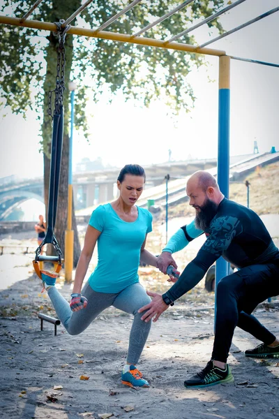 Man training woman on special equipment