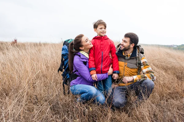 Happy family with backpacks embracing