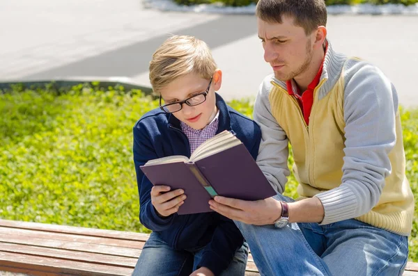 Young man is helping teenager to read a book
