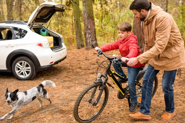 Father teaching son to ride bicycle