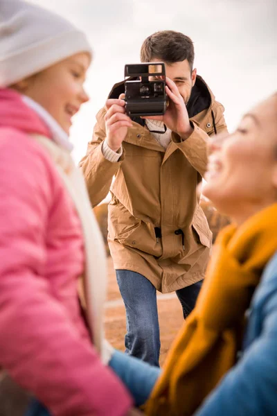 Man photographing happy mother and daughter