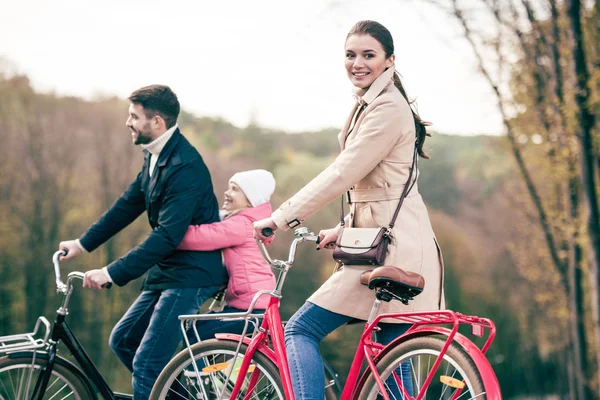 Happy family riding bicycles in park