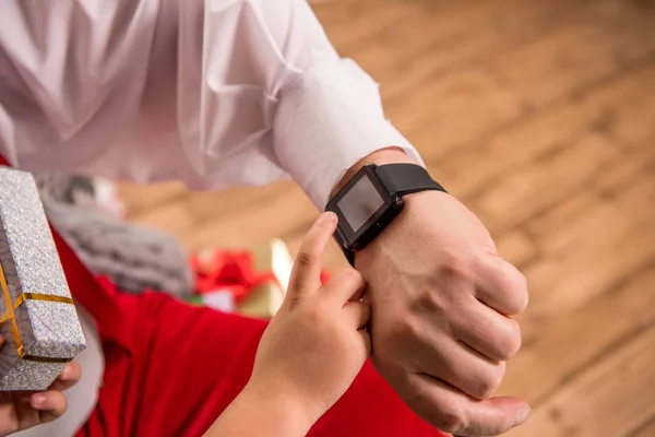 Hand with smartwatch and child finger
