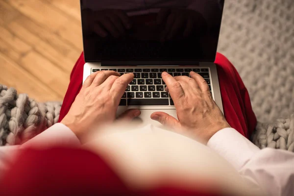 Santa Claus typing on laptop