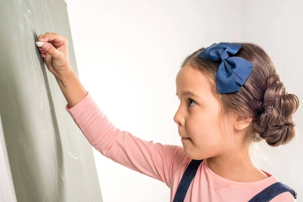 Schoolgirl drawing on blackboard