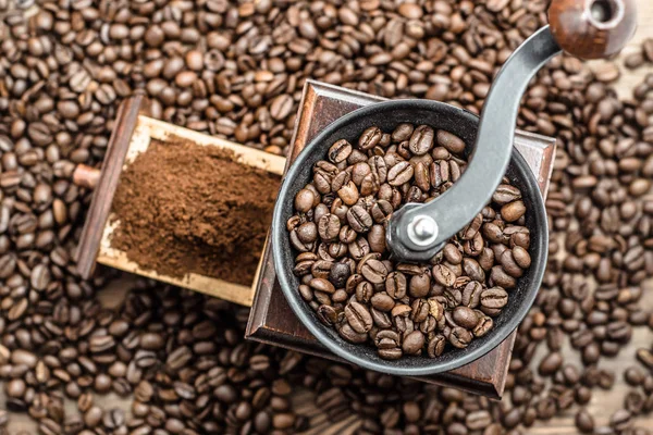 Manual coffee mill with roasted coffee beans, top view