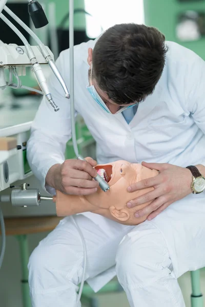 Dental student practicing on doll.