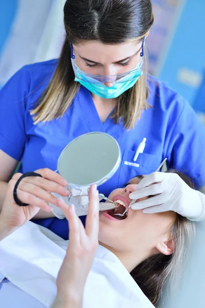 Female Dentist examining Patient teeth
