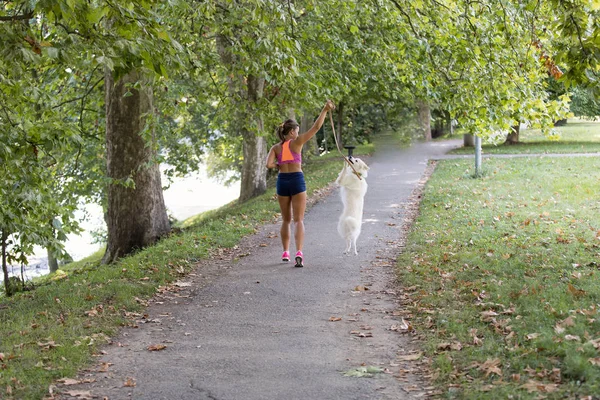 Young girl running with dog in park