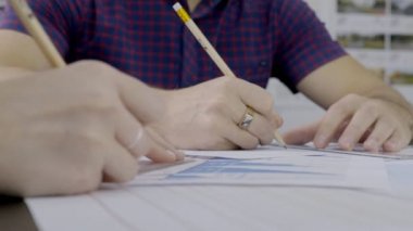 На стол два инженера Нарисуйте правителя и карандашом на листе — стоковое видео На стол два инженера Нарисуйте правителя и карандашом на листе — стоковое видео